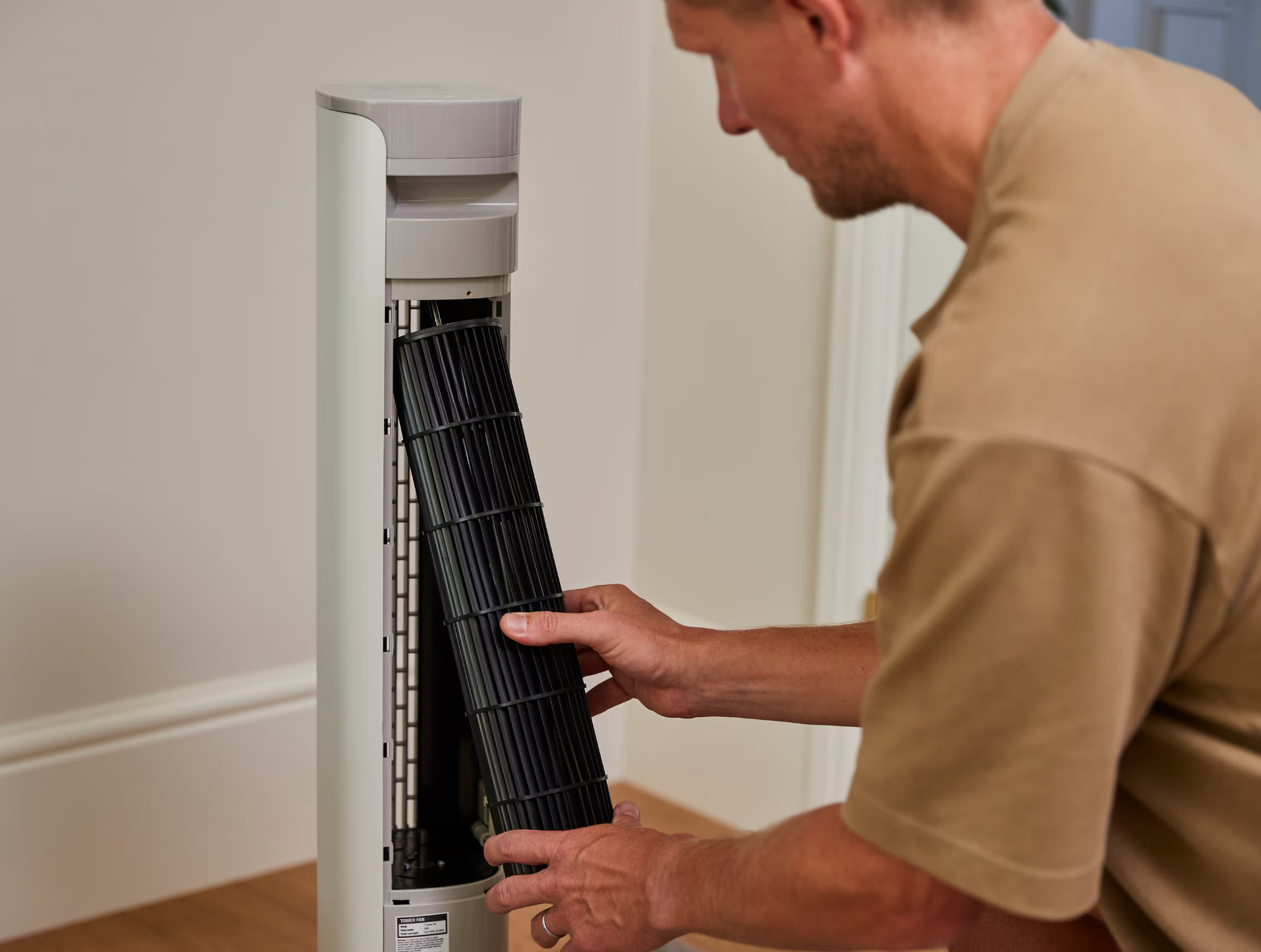 Ein Mann ist dabei, seinen Sefte Turmventilator zu reinigen.